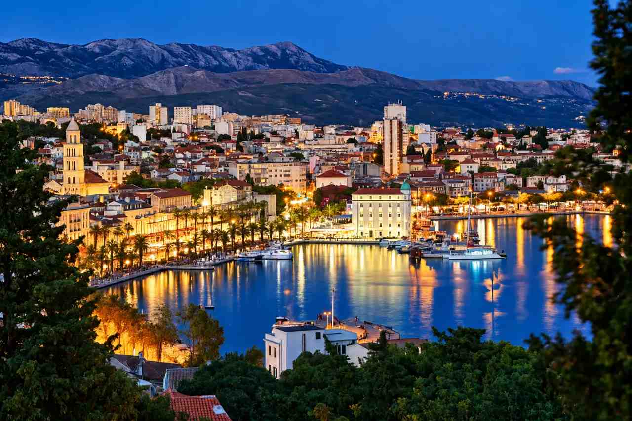 Split's harbour and old town lit up in the evening, seen from Marjan hill