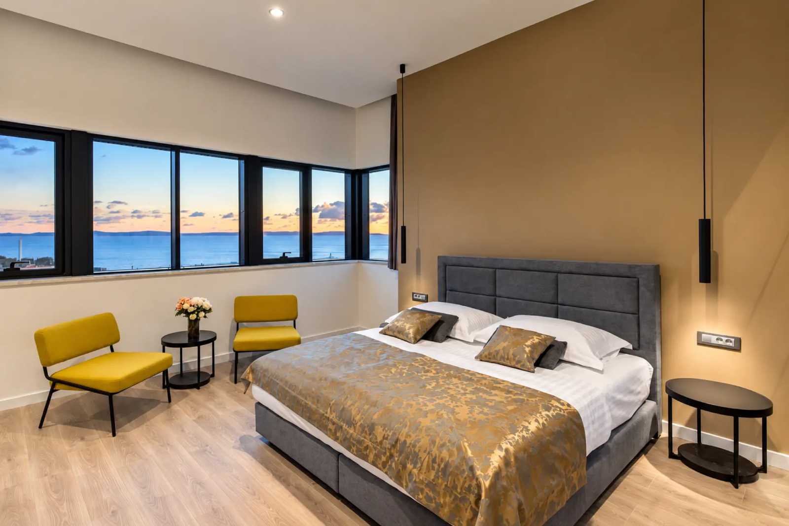 Guest room at Seascape Luxury Rooms with a wide sea view at sunset